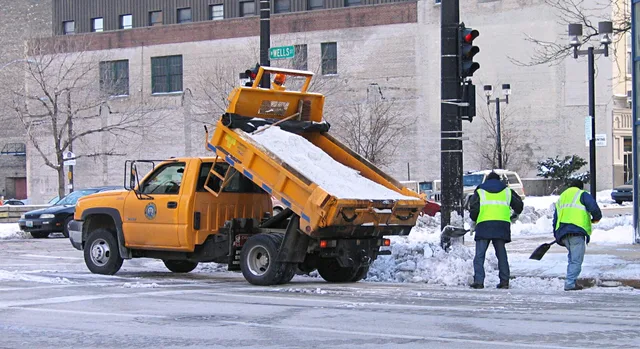 Workers manually spreading salt from a salt truck in Milwaukee, Wisconsin. Winter salt and slush, a Canadian carpet care calendar